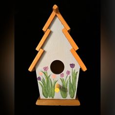 a bird house with flowers painted on it