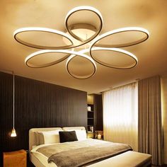 a bed sitting under a ceiling light in a bedroom