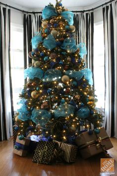 a blue christmas tree with presents under it