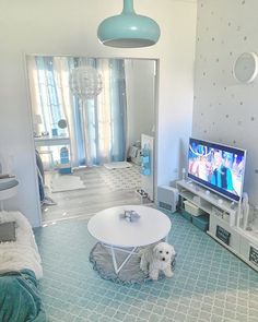 a living room filled with furniture and a flat screen tv on top of a white table