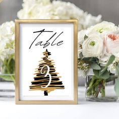 a table with flowers and a sign that says table number 9 in gold foil on it