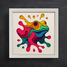 an abstract paper cut art piece with multicolored paint splattered on it