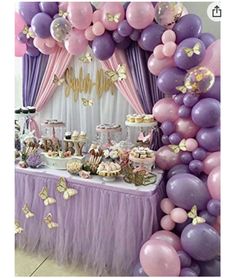 a purple and pink dessert table with lots of balloons