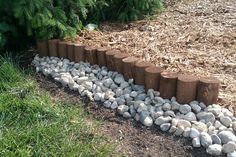 a row of logs sitting next to a pile of rocks