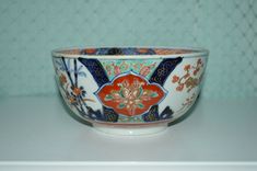 a colorful bowl sitting on top of a white counter next to a green and blue wall