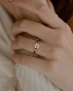 a woman's hand with a diamond ring on it