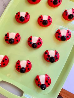 ladybug cookies are arranged on a green tray