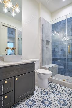 a bathroom with blue and white tile flooring next to a walk - in shower