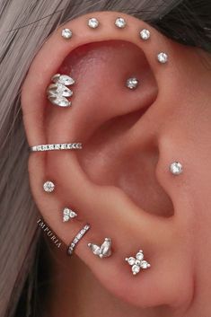 a woman's ear with three different piercings