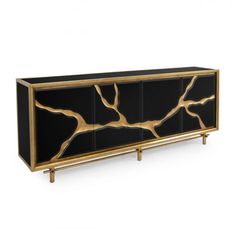 a black and gold sideboard with branches on it