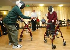 two men in masks are playing video games with walkers and other people behind them