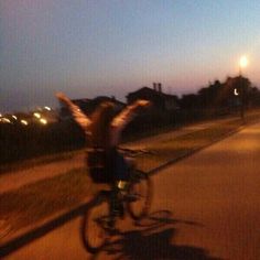 a blurry photo of a person riding a bike with their arms in the air