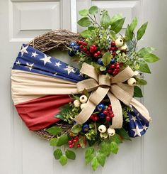 an american flag wreath with berries and greenery on the front door for memorial day