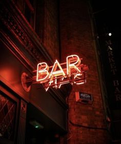 a neon bar sign on the side of a building