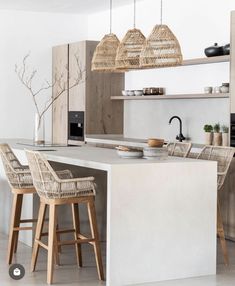 a kitchen with two stools next to a counter and some lights hanging from the ceiling