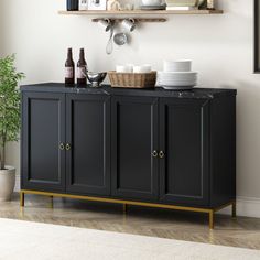 a black cabinet with wine bottles and plates on it next to a potted plant