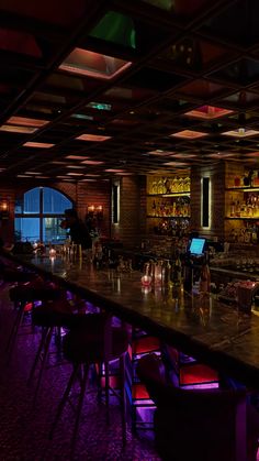 a dimly lit bar with lots of stools