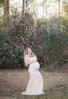 a pregnant woman in a white dress is surrounded by confetti