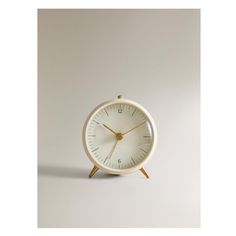 a small white clock sitting on top of a table