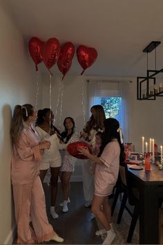 a group of women standing next to each other in front of a dining room table