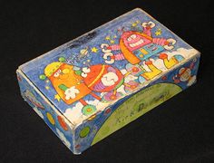 a box with cartoon characters painted on it sitting on a black tablecloth covered surface