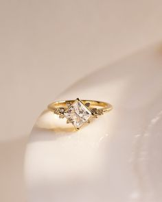 a diamond ring sitting on top of a white surface