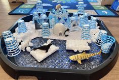 an ice castle made out of water bottles and plastic toys on a table with other items