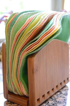 a stack of folded towels sitting on top of a wooden holder