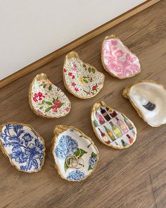 six decorative dishes are sitting on the floor in front of a white wall and wood floor