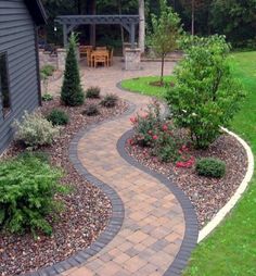 a brick walkway in the middle of a yard