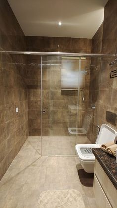 a bathroom with a glass shower door and toilet