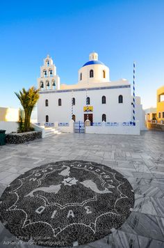 a white building with blue and white decorations on the ground in front of some trees