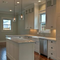 an empty kitchen with white cabinets and stainless steel dishwasher in the center island