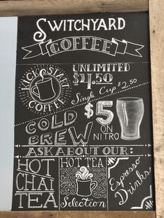 a chalkboard sign with different types of drinks and prices on it's side