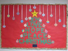 a bulletin board with ornaments hanging from it's sides and the words joy love hope peace christmas