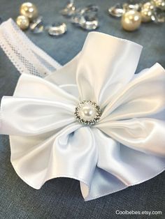 White satin flower headband on elastic band.  Accented with rhinestones centrepiece.  All embellishments will vary based on availability. An equal or better quality will be used if necessary. Please reach out with any modifications to the headband if needed.  Matching barefoot sandals - https://www.etsy.com/ca/listing/521566456/baptism-barefoot-sandals-infant-barefoot Processed/made within 3-5 business days plus shipping 7-10 days regular mail. Express shipping is available for 2-3 days. Happy S Lace Barefoot Sandals, Vintage Flower Girls, Headband Pearl, Flower Girl Headbands, Satin Headband, Baby Pearls, Christening Outfit