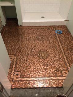 a bathroom with a tiled floor next to a shower