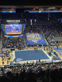 an indoor basketball court with people watching the game