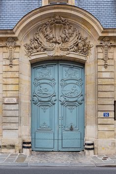 an old building with two large blue doors