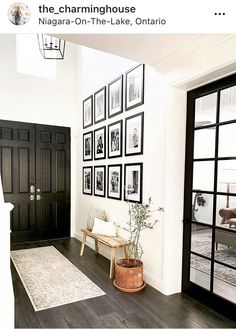 a living room filled with furniture and framed pictures on the wall above it's doorway