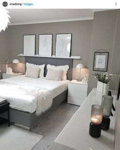 a bed room with a neatly made bed and some pictures on the wall above it