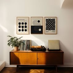 there are three pictures on the wall above a record player