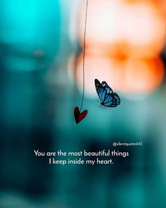 a blue butterfly hanging from a string with a quote on it that says, you are the most beautiful things i keep inside my heart