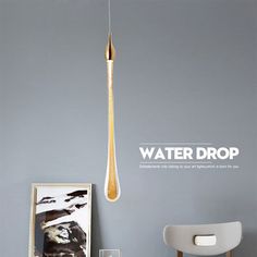 a room with a chair, table and painting on the wall that says water drop