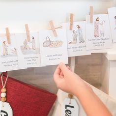 a person holding up some cards with pictures on them and clothes pins attached to it