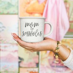 a woman holding a coffee cup with the words mom of seashells on it