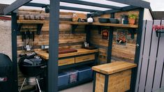 an outdoor kitchen made out of pallets and wooden planks is shown in this backyard