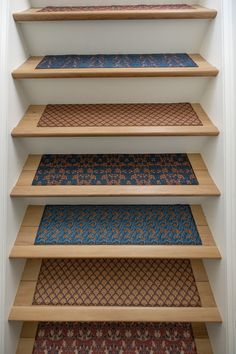 a set of four wooden shelves with different colored carpet on the top and bottom floors