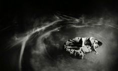 a black and white photo of a person floating in water