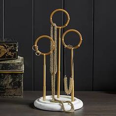 a gold and white jewelry stand on top of a wooden table